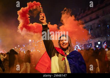 Paris, Frankreich. 19.. Dezember 2022. Ein Fußballfan erhebt einen roten Rauch zur Unterstützung der französischen Fußballmannschaft. Französische Fußballfans versammeln sich auf den Champs Elysees in Paris, um ihre Nationalmannschaft zu unterstützen, die sie während des Finales der FIFA-Weltmeisterschaft Katar 2022 am 18. Dezember 2022 gegen Argentinien spielen. Argentinien wird schließlich zum Gewinner gekrönt, nachdem es 4-2 in Elfmetern gewonnen hat, obwohl die beiden Teams in der Verlängerung ein Unentschieden von 3-3 erreichen. Kredit: SOPA Images Limited/Alamy Live News Stockfoto