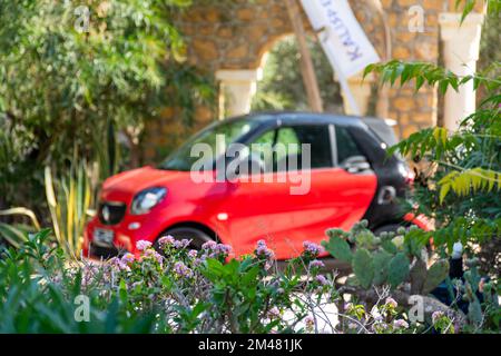 Ein roter Smart für zwei Autos auf dem Hotelparkplatz an einem schönen sonnigen Tag. Stockfoto