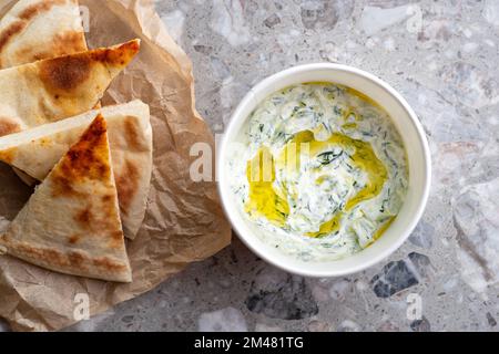 Der traditionellen griechischen Tzatziki dip Sauce mit Gurken saure Sahne, griechischer Joghurt, Zitronensaft, Olivenöl und einen frischen Zweig Dill Unkraut. Mit t serviert. Stockfoto