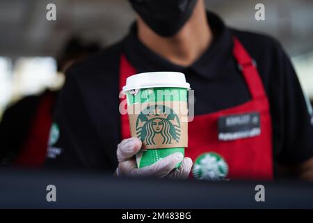 Starbucks Mitarbeiter geben Befehle am Drive-in. Heißer Kaffee auf exklusiver Weihnachtsverpackung. Saudi-Arabien, Khobar, 18. Dezember 2022. Stockfoto