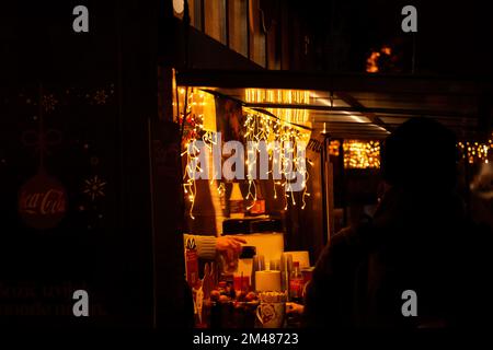 Zagreb, Kroatien - 8. Dezember 2022: Weihnachtsfeier von Coca Cola in Zagreb. Wohltätigkeitsessen, trinken fair. Markthaus aus Holz mit Girlanden. W Stockfoto