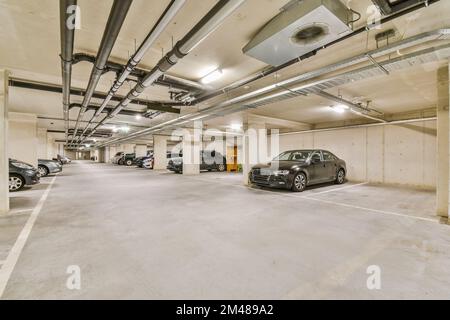 Eine Tiefgarage mit Autos, die auf dem Parkplatz geparkt sind und niemand auf dem Boden, um zu sehen, wie es läuft Stockfoto