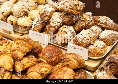 Eine Mischung aus Backwaren, die wunderschön auf einem Regal angeordnet sind, einschließlich Croissants Stockfoto