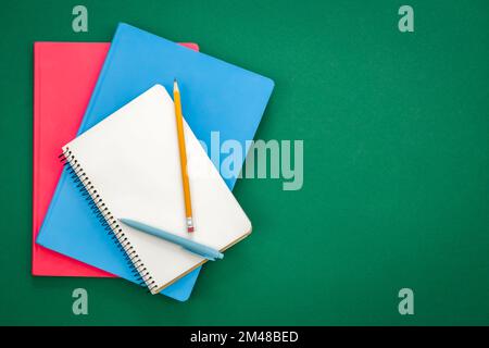Notizbücher auf grünem Hintergrund, Schulkonzept, flach liegend. Stockfoto