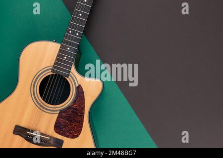 Akustikgitarre auf farbigem Hintergrund, flach liegend. Stockfoto