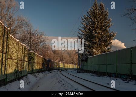 Verschneite eisige Eisenbahn in der Nähe der Stadt Ceske Budejovice mit großem Nadelbaum Stockfoto