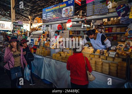 Menschen, die Käse und Lebensmittel in Geschäften und Märkten in der Innenstadt von Cusco, Peru, einkaufen Stockfoto