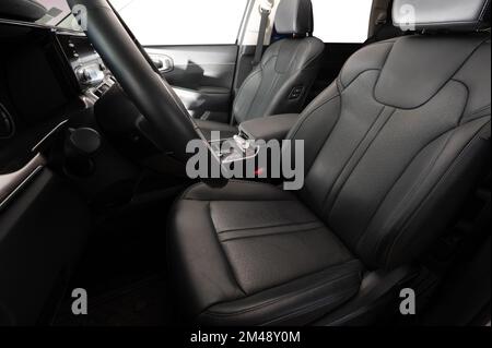Sitze in schwarzem, sauberem Leder in modernem Fahrzeuginnenraum, Seitenansicht Stockfoto