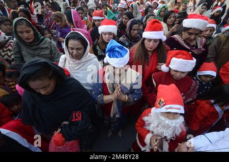 Peshawar, Pakistan. 18.. Dezember 2022. Mitglieder der christlichen Minderheit Pakistans, die als Weihnachtsmann verkleidet sind, nehmen an einer vor Weihnachten stattfindenden Rallye in einer Straße in Peshawar Teil. Pakistan ist ein muslimisches Land mit sunnitischer Mehrheit und vier Millionen Christen von einer Gesamtbevölkerung von etwa 200 Millionen Menschen. (Foto: Hussain Ali/Pacific Press/Sipa USA) Guthaben: SIPA USA/Alamy Live News Stockfoto