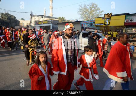 Peshawar, Pakistan. 18.. Dezember 2022. Mitglieder der christlichen Minderheit Pakistans, die als Weihnachtsmann verkleidet sind, nehmen an einer vor Weihnachten stattfindenden Rallye in einer Straße in Peshawar Teil. Pakistan ist ein muslimisches Land mit sunnitischer Mehrheit und vier Millionen Christen von einer Gesamtbevölkerung von etwa 200 Millionen Menschen. (Foto: Hussain Ali/Pacific Press/Sipa USA) Guthaben: SIPA USA/Alamy Live News Stockfoto