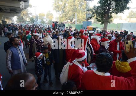 Peshawar, Pakistan. 18.. Dezember 2022. Mitglieder der christlichen Minderheit Pakistans, die als Weihnachtsmann verkleidet sind, nehmen an einer vor Weihnachten stattfindenden Rallye in einer Straße in Peshawar Teil. Pakistan ist ein muslimisches Land mit sunnitischer Mehrheit und vier Millionen Christen von einer Gesamtbevölkerung von etwa 200 Millionen Menschen. (Foto: Hussain Ali/Pacific Press/Sipa USA) Guthaben: SIPA USA/Alamy Live News Stockfoto