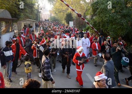 Peshawar, Pakistan. 18.. Dezember 2022. Mitglieder der christlichen Minderheit Pakistans, die als Weihnachtsmann verkleidet sind, nehmen an einer vor Weihnachten stattfindenden Rallye in einer Straße in Peshawar Teil. Pakistan ist ein muslimisches Land mit sunnitischer Mehrheit und vier Millionen Christen von einer Gesamtbevölkerung von etwa 200 Millionen Menschen. (Foto: Hussain Ali/Pacific Press/Sipa USA) Guthaben: SIPA USA/Alamy Live News Stockfoto