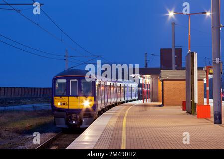 Der Elektrozug der Northern Rail-Klasse 319 319366 am Bahnhof Wigan North Western wartet im Morgengrauen auf die Abfahrt Stockfoto