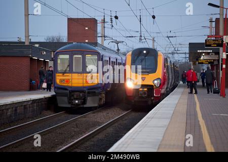 Virgin Train Diesel voyager Train und Northern Rail Class 319 Electric Train am Bahnhof Wigan North Western an der Westküste der Hauptlinie. Stockfoto