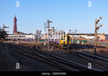 Ein Express-Sprinter-Zug der Klasse 158 fährt in Blackpool North ab, der zwischen den Signalen des Blackpool Tower zu sehen ist Stockfoto