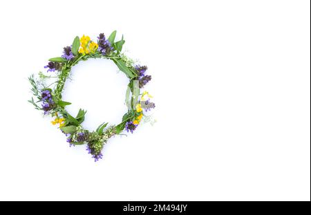 Ein wunderschöner Kranz aus Wildblumen auf weißem Hintergrund. Stockfoto