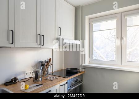 Moderne, kleine, helle Kücheneinrichtung bei Tageslicht Stockfoto