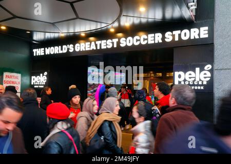 Leute, die am Sportgeschäft Pele Soccer in Times Square, New York City, vorbeilaufen, 14. Dezember 2022. Stockfoto