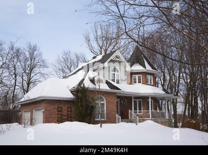 Roter Backstein mit grauen und weißen Zierleisten neues viktorianisches Landhaus im Winter. Stockfoto