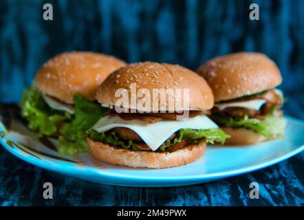 Aus der Nähe sehen Sie drei köstliche hausgemachte Burger auf einem Teller Stockfoto