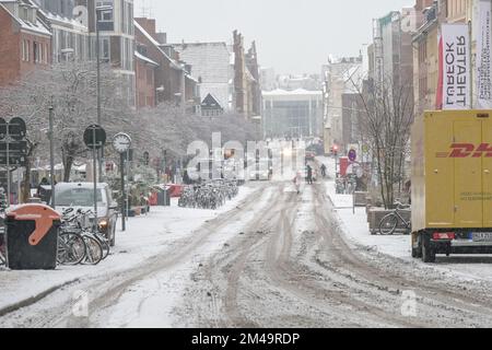 Lübeck, Deutschland, 15. Dezember 2022: Schnee und Schlamm auf einer Stadtstraße, gefährliches Wetter für Pkw und Fußgänger, Winterverkehrskonzept, Kopierraum, s Stockfoto