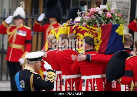 PA REVIEW OF THE YEAR 2022 File Photo dated 19/09/22 - King Charles III salutiert den Sarg von Königin Elizabeth II., bedeckt mit der kaiserlichen Staatskrone und der Kugel und dem Zepter des Sovereign, während er während der Staatsbeerdigung in die Westminster Abbey gebracht wird. Ausgabedatum: Dienstag, 20. Dezember 2022. Stockfoto