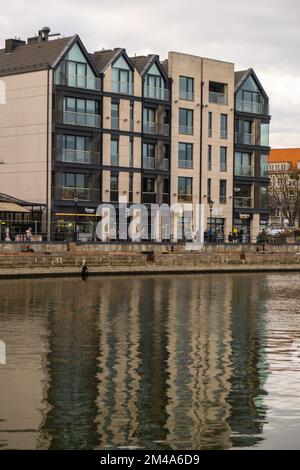 Danzig, Polen Mai 2022, moderne Gebäude über dem Motlawa-Fluss in der Altstadt. Tourismus auf dem Motlawa River. Neue Apartments-Architektur auf Granary Island Glasfenster mit Reflexionen. Touristisches Reiseziel Stockfoto