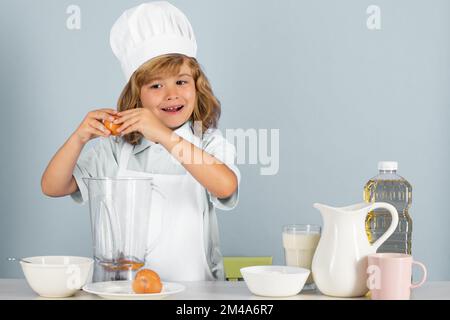 Kinderkoch isoliert auf blau. Lustige kleine Koch Koch Koch tragen einheitliche Kochmütze und Schürze gekocht Essen in der Küche. Stockfoto