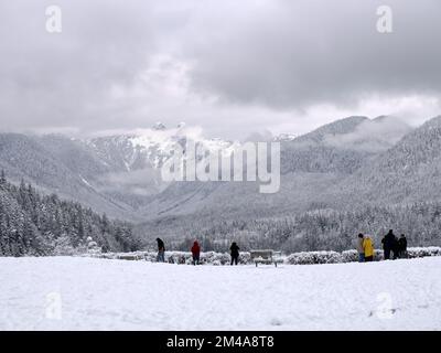 Besucher genießen den wunderschönen Blick auf die verschneite Winterlandschaft im Capilano River Regional Park in North Vancouver, British Columbia, Kanada Stockfoto