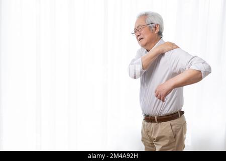 Ein ranghöchster Chinese leidet an Schulterschmerzen Stockfoto