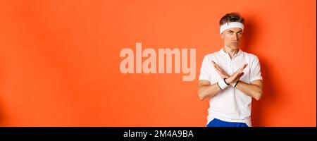 Konzept von Sport, Fitness und Lifestyle. Porträt eines ernsthaft aussehenden männlichen Trainers mit Kreuzzeichen, zu sagen, zu stoppen, etwas zu verbieten und auszudrücken Stockfoto