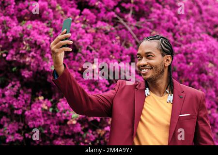 Ein cooler afrikanischer Mann macht ein Selfie im Garten Stockfoto