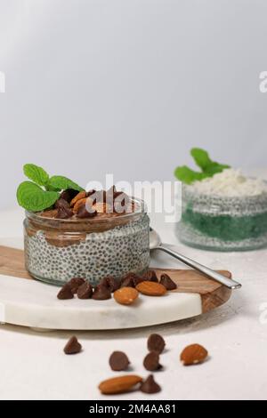 chia Pudding mit Schokolade und Mandeln auf weißem Tisch Stockfoto