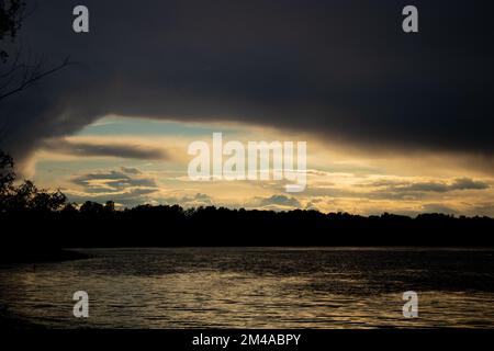 Gewitterwolken bei Sonnenuntergang über dem Dnieper River Stockfoto