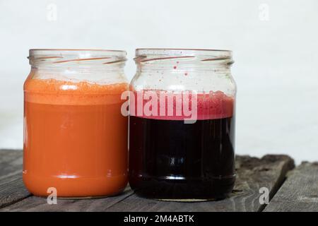 Frisch gepresster Karotten- und Rote-Bete-Saft in den Banken am Morgen auf einem Tisch Stockfoto