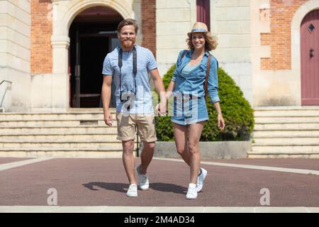 Junge Touristen, die auf der Straße der Stadt spazieren und Fotos machen Stockfoto