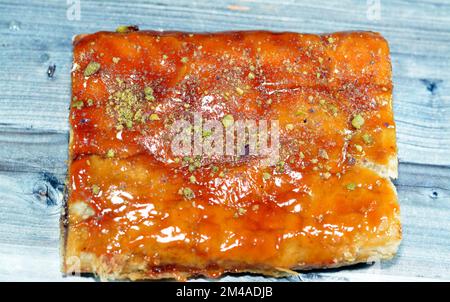 Apfelkuchen gefüllt mit cremigem Apfel, Zimt und süßem Honigsirup und garniert mit Pistazien, köstlicher süßer gebackener Apfelkuchen, fertig Stockfoto