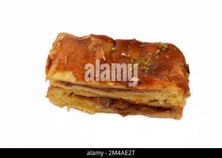 Apfelkuchen gefüllt mit cremigem Apfel, Zimt und süßem Honigsirup und garniert mit Pistazien, köstlicher süßer gebackener Apfelkuchen, fertig Stockfoto