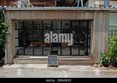 Außendesign und Frontstore-Dekoration der lokalen Kaffeebar und Bäckerei, dekoriert mit Fensterglasrahmen und Holzstruktur Stockfoto