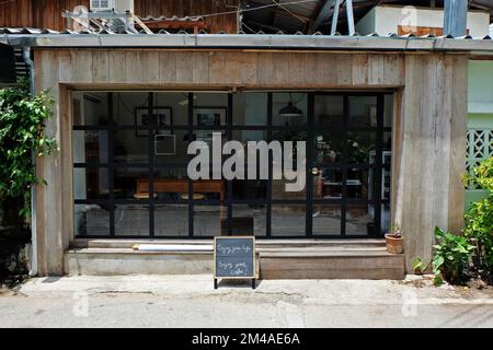 Außendesign und Frontstore-Dekoration der lokalen Kaffeebar und Bäckerei, dekoriert mit Fensterglasrahmen und Holzstruktur Stockfoto