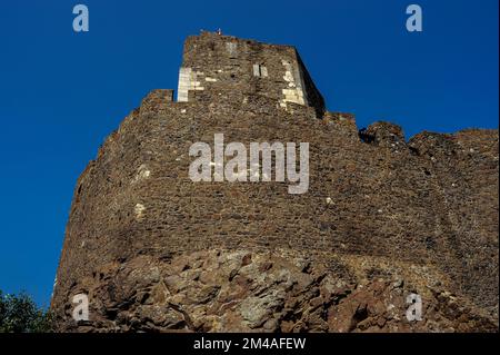 Die alten Trümmermauern der nordungarischen Burg Hollókő tragen die Narben jahrhundertelanger Belagerungskriege sowie offensichtliche Hinweise auf Reparaturen, die über mehrere Jahrzehnte hinweg durchgeführt wurden. Die Festung, die in den späten 1200s Jahren im Cserhát-Hochland erbaut wurde, wurde zu verschiedenen Zeiten von lokalen Kriegsherren, osmanischen Türken, Hussiten und Befreier unter der Führung des Königs von Polen gehalten. Stockfoto