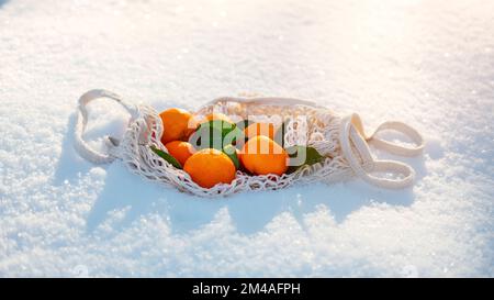Bestes Obst der Saison für frigide kalte Wintermonate. Orange und Tangerinen Winterfrucht für Diabetes, Gewichtsverlust, Haut. Orange und Mandarinen auf Schnee Stockfoto