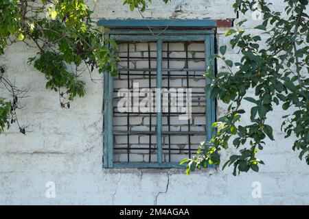 Backsteinfenster und Gitter in einem verlassenen Haus Stockfoto