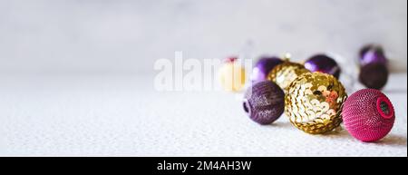 Festliches Weihnachtsthema mit goldpinkfarbener violetter Kugel-LED-Girlande und goldlila Weihnachtsschmuck. Weihnachtskomposition Dekoration, verstanden Stockfoto