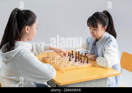 Zwei chinesische Mädchen spielen Schach Stockfoto