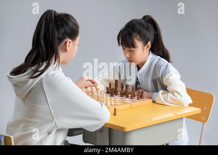 Zwei chinesische Mädchen spielen Schach Stockfoto