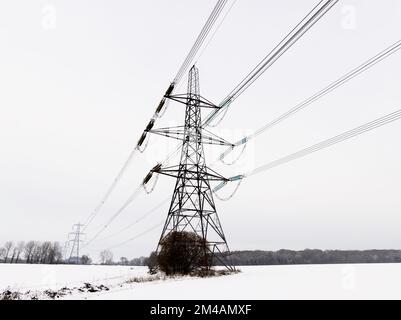 Strommasten in einer Winterlandschaft mit Schnee. UK Stockfoto