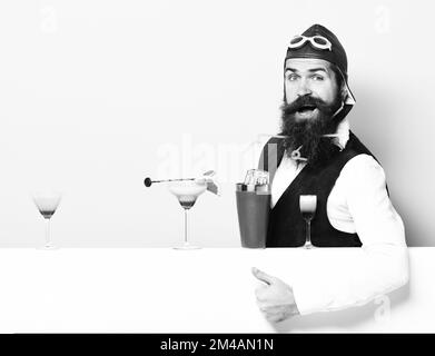 Schöne bärtige Aviator oder Pilot mit Bart und Schnurrbart auf lächelnde Gesicht mit Shaker alkoholische Cocktails in Vintage Leder weste mit Hand Stockfoto