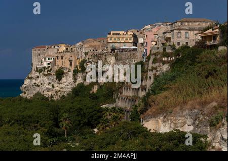 Beliebte und Balkone mit Blick auf das Mittelmeer des rauchenden Vulkans Stromboli: Die Altstadt von Tropea ion an der Westküste von Kalabrien, Süditalien, hoch oben auf steilen Sandsteinklippen über üppiger Vegetation, feinen Sandstränden und einem türkisfarbenen Meer. Stockfoto