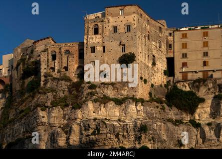 Aus dem hügeligen Gipfel der Sandsteinklippen, die die historische Altstadt von Tropea an der Costa degli Dei (Küste der Götter) im Westen Kalabriens, Süditalien, stützen, scheinen ältere Steinbauten zu wachsen. Stockfoto